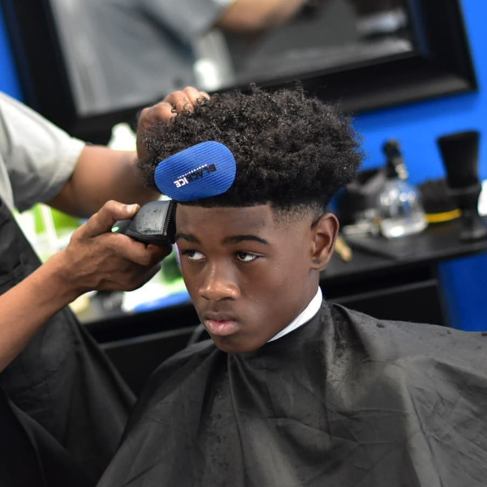 Young black boy with afro getting lineup