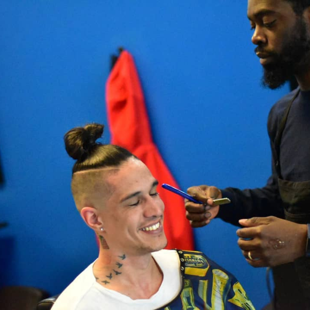 white male smiling with topknot
