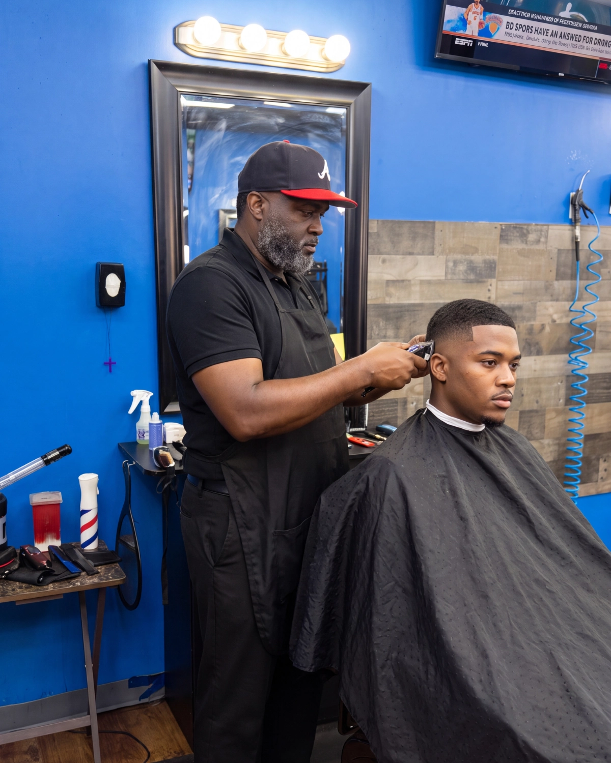 John Threat cutting hair at 2 Elite Barber Shop in Kennesaw.