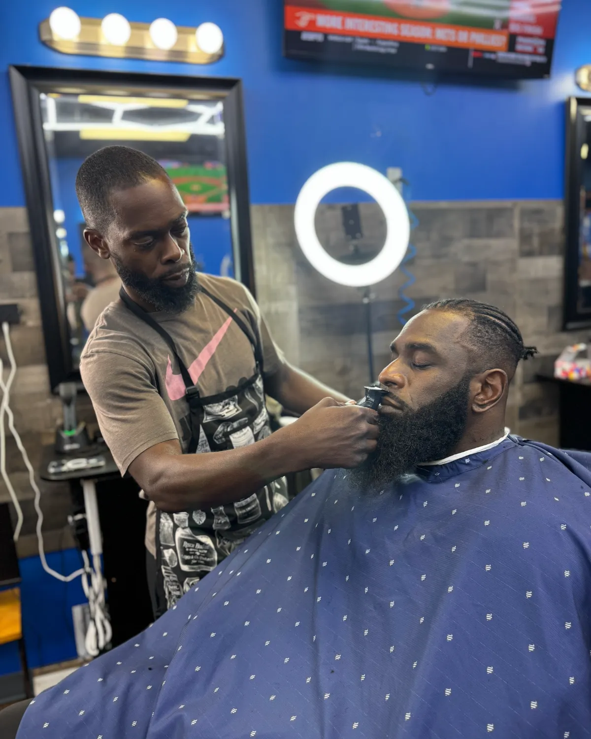 Chris cutting a client's hair at 2 Elite Barber Shop in Kennesaw.